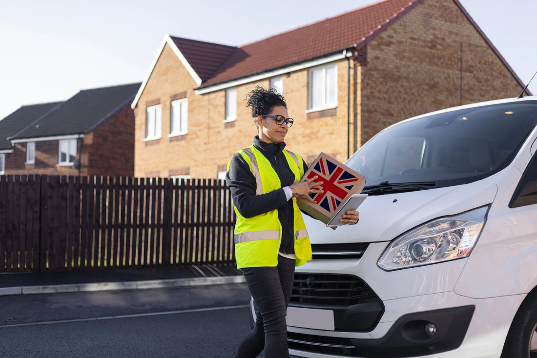 A woman in a high-visibility vest standing next to a van, holding a box with the Union Jack flag, illustrating EPR UK logistics and producer responsibilities.